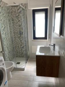 a bathroom with a shower and a sink and a toilet at SeaYouSoverato Apartment in Soverato Marina