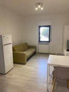 a living room with a couch and a refrigerator at SeaYouSoverato Apartment in Soverato Marina +9 photos