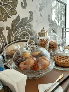 a table with a glass dish of pastries and cookies at Lacerno Rooms in Pescosolido