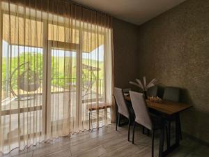 a dining room with a table and a large window at Arevot Ojakh in Areni