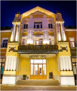 ein gelbes Gebäude mit einer Veranda und einer Tür in der Unterkunft Hotel Lev in Levice