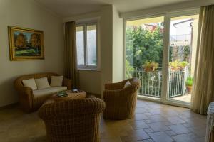 a living room with chairs and a couch and a balcony at Nosside & Saffo Guesthouse in Amantea