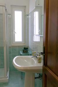 a bathroom with a sink and a window and a mirror at Nosside & Saffo Guesthouse in Amantea