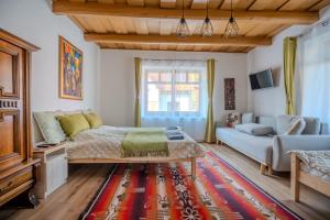 a living room with a bed and a couch at Kiskörtés Vendégház Óhuta in Háromhuta