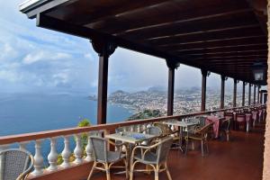 a balcony with tables and chairs overlooking the ocean at Ocean Gardens in Funchal