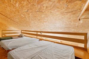 two beds are in a room with a stone wall at Le Nid in Abbaretz