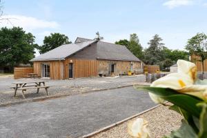 a building with a picnic table and a bench in front of it at Le Nid in Abbaretz