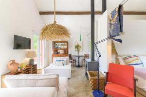 a living room with white furniture and a red chair at Cozy Countryside Studio in Aldeia do Cano
