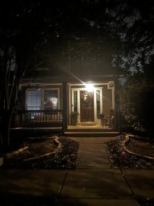 a house with a light on the door at night at Quaint & Vivacious Room-Queen in Kyle