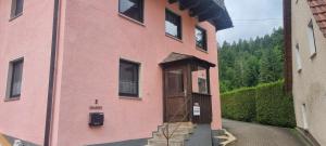 a pink building with a door on the side of it at FeWo Mephisto in Pottenstein +23 photos