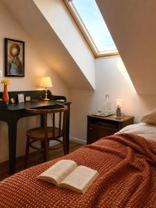 a bedroom with a bed and a desk with a book at Hatablak Boutique Guesthouse in Köveskál in Köveskál