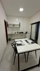 a table and chairs in a room with a kitchen at Casa nova, confortável e funcional em Redação-PA in Redenção +11 photos