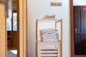 a stack of towels on a shelf in front of a mirror at Kiskörtés Vendégház Óhuta in Háromhuta +35 photos