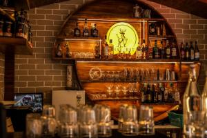 a bar with a clock on a wall with glasses at Hotel Shaurrat in Shimla