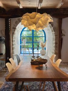 a dining room with a wooden table and a large window at Villa Bakola in Sívros