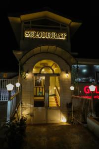 a building with a sign that readshareart with a door at Hotel Shaurrat in Shimla
