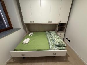 a small bed in a room with white cabinets at Casa ajolote in Cunardo