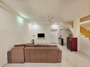 a living room with a couch and a tv at JAGUAR VILLA II 3BHK II AC II POOL Il EMPYREAN STAY in Lonavala