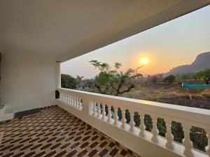 a balcony with a view of the sunset at JAGUAR VILLA II 3BHK II AC II POOL Il EMPYREAN STAY in Lonavala
