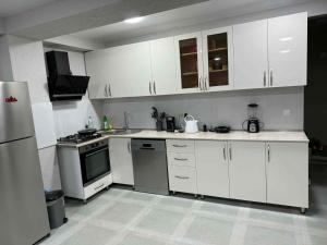 a kitchen with white cabinets and a refrigerator at Grigoleti Royal in Grigoleti +11 photos