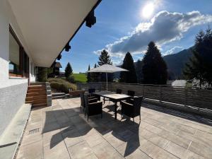 a patio with a table with chairs and an umbrella at Ferienwohnung Heid in Rettenberg