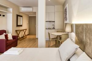 a room with a bed and a kitchen with a table at Aparthotel 1904 in Figueres