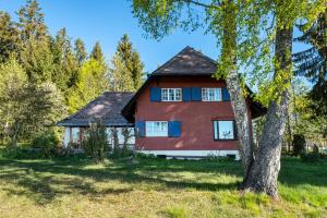 a red house with a tree in front of it at Kleines Waldglück in Lenzkirch