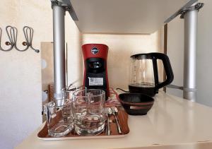 a tray of glasses on a counter with a blender at Crisalide in La Maddalena