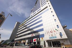 a tall building with cars parked in front of it at Dolphin Continental Hotel in Kuwait