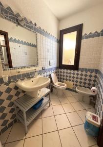 a bathroom with two toilets and a sink and a mirror at Crisalide in La Maddalena