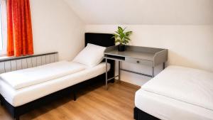 a small room with two beds and a desk at Basic Work Stay Rooms - Highspeed WiFi - Easy Self Check-In - Practical and Affordable Stay in Bürs