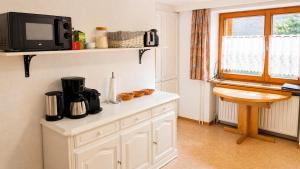 a kitchen with a counter with a microwave and a tv at Basic Work Stay Rooms - Highspeed WiFi - Easy Self Check-In - Practical and Affordable Stay in Bürs +8 photos
