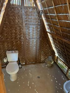 a bathroom with a toilet in a wooden wall at Lumindas Beach Resort in Sabang