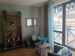 a living room with a large window and a table at Marmande in Marmande