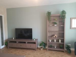 a living room with a television on a wooden entertainment center at Marmande in Marmande