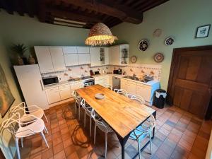 a large kitchen with a wooden table and chairs at Capsule camelia un charme Montois in Mons
