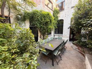 a table and chairs in the courtyard of a building at Capsule camelia un charme Montois in Mons