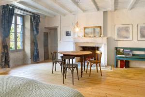 a room with a table and chairs and a fireplace at Idyl 2020 in Migré