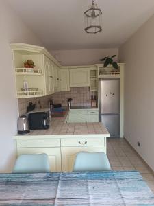 a kitchen with white cabinets and a blue refrigerator at Marmande in Marmande