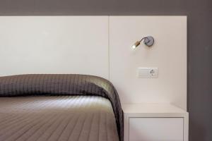 a bedroom with a bed with a clock on the wall at Cala Figuera Apartment 1b in Cala Figuera