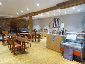 a restaurant with tables and chairs and a counter at Habitation Occitania in Durban-Corbières
