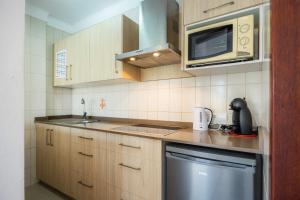 a small kitchen with a microwave and a sink at Cala Figuera Apartment 1b in Cala Figuera