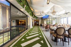 a restaurant with tables and chairs on a balcony at Dolphin Continental Hotel in Kuwait