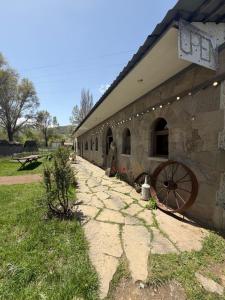 an old stone building with a large wheel on it at Saro B&B in Tatev in Tandzatapʼ