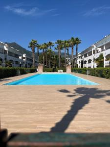 a large swimming pool with palm trees and buildings at APPARTEMENT sognu di rena G1 in San-Nicolao