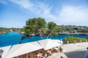 a view of the water from a restaurant with an umbrella at Cala Figuera Apartment 1b in Cala Figuera