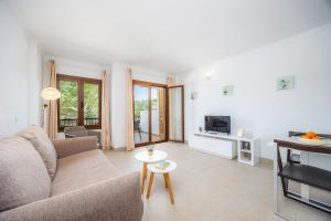 a living room with a couch and a tv at Cala Figuera Apartment 1b in Cala Figuera