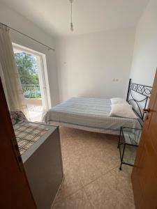a bedroom with a bed and a chair in it at Ionian Sunset Drymades in Gjilek
