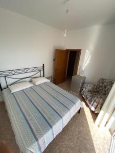 a bedroom with a large bed and a chair at Ionian Sunset Drymades in Gjilek