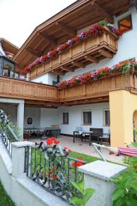 a house with a balcony with flowers on it at Appartements Agnes in Fulpmes